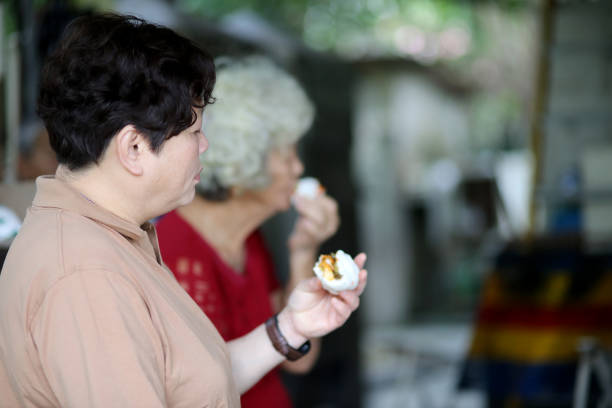 Asian senior women are enjoying freshly steamed bun