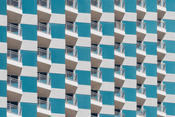 White building facade pattern with circular balconies and flowering plants.