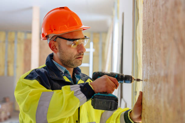 istock Male construction worker working at a home construction project drilling in drywall 2191476169