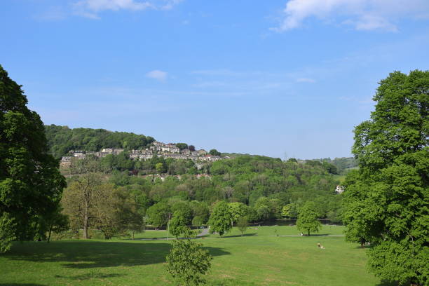 istock Sunny spring day in Shibden Park with green grass, trees, and a bright blue sky 2191476779