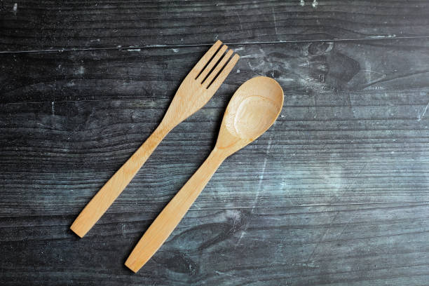istock wooden fork and spoon isolated on black wooden board background 2191477148