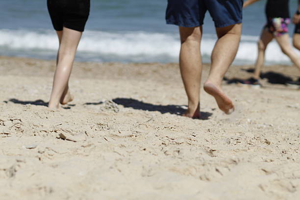 istock people's feet in the sand on the beach 2191480121