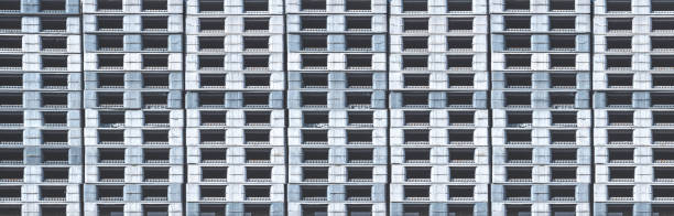 istock Row of many plastic pallets stack in panoramic background outside of distribution shipping warehouse 2191481422