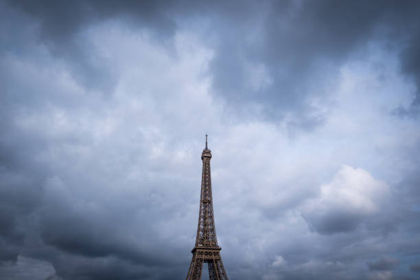 istock The tip of the Eiffel Tower against a backdrop of clouds 2191481606
