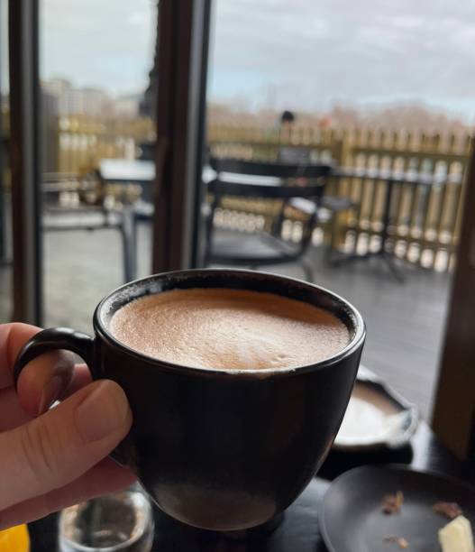 istock Coffee in black cup with outdoor window scene 2191482803