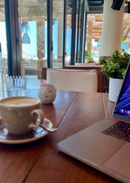 Laptop angle and coffee on wooden table in cafe