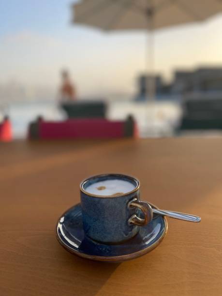 istock Macchiato coffee with blurred pool and sun umbrella background 2191483040