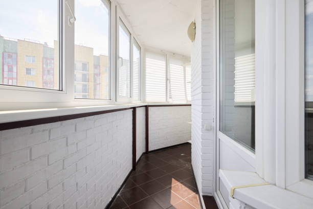 istock A modern sunlit balcony featuring pristine white walls complemented by warm brown flooring 2191483551