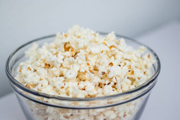 istock Tasty popcorn in a glass bowl on white table background 2191484615