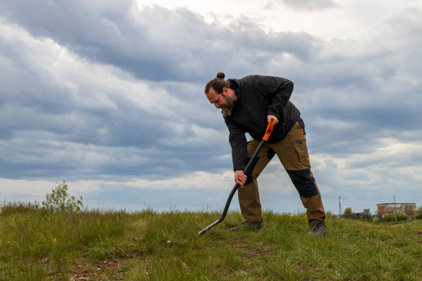 istock A man is digging in the grass with a metal shovel 2191485632