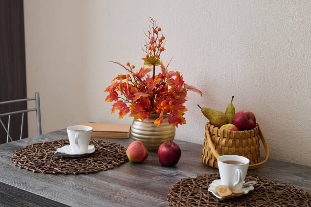 A Beautiful Autumn Table Setting Featuring an Elegantly Arranged Display of Flowers and Fresh Fruits