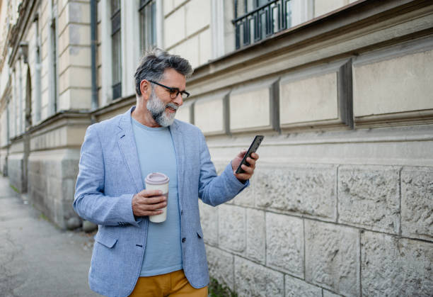 istock Man walking down the street and checking cellphone 2191486156