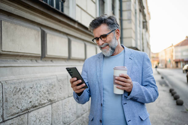 istock Man walking down the street and checking cellphone 2191486289