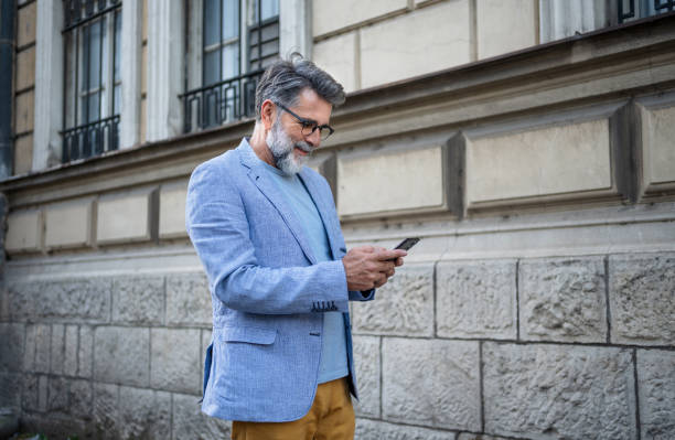 istock Mature man using phone outdoors 2191486293