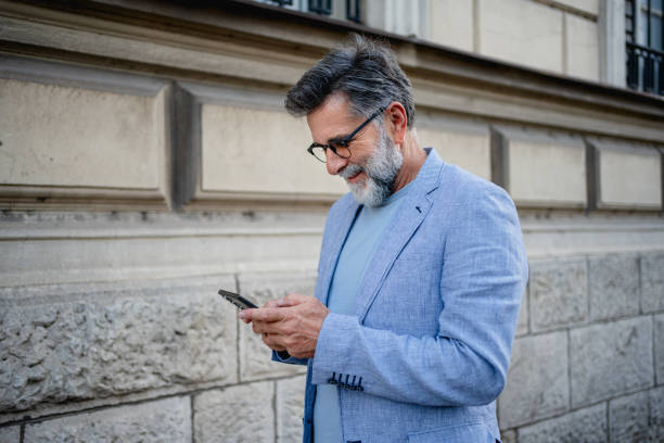 istock Mature man using phone outdoors 2191486336