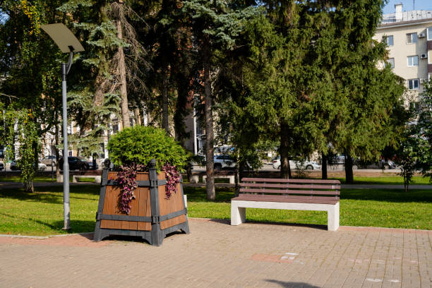 istock There is a beautiful park that features a comfortable bench placed thoughtfully in the center, surrounded by a lovely planter filled with vibrant plants, providing a serene atmosphere 2191487369
