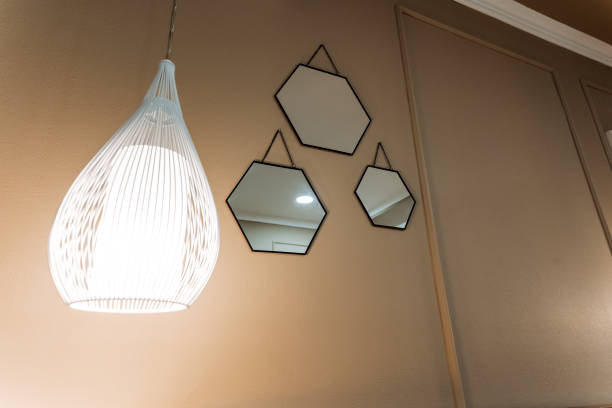 istock Three exquisite mirrors hang gracefully on the wall beside a chic light fixture, creating a captivating interplay of reflections and light that beautifully enhances the space 2191489583
