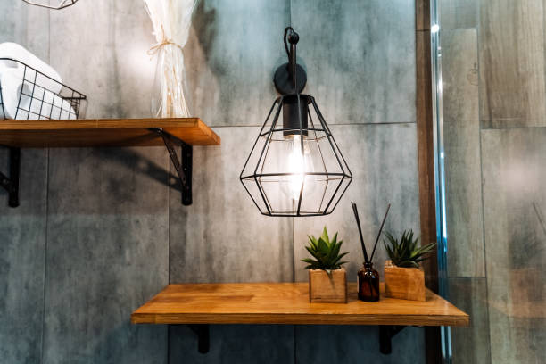 A beautifully crafted wooden shelf adorned with various potted plants placed on it, accompanied by a soft light hanging gracefully from the ceiling above, creating a warm ambiance