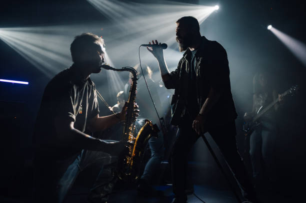 istock Band performing live music on stage with saxophone and microphone 2191490149