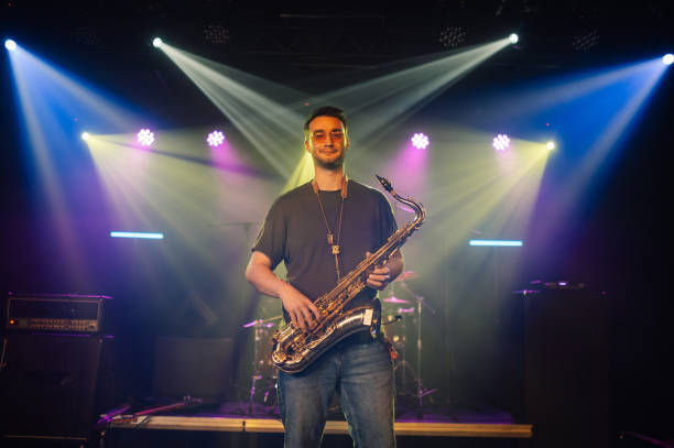 istock Saxophonist performing live on stage under colorful lights 2191490158