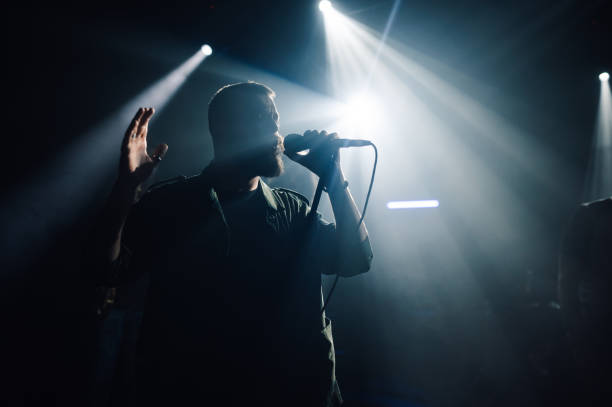 istock Singer performing live on stage with spotlights 2191490160