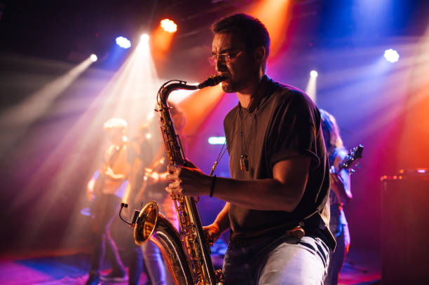 istock Saxophonist performing live on stage with band 2191490163