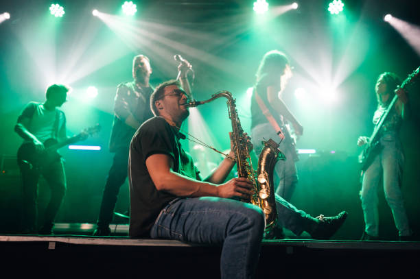istock Saxophonist performing with band on stage during concert 2191490173