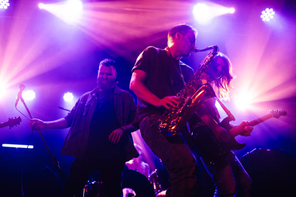istock Musicians playing saxophone and guitar on stage 2191490177