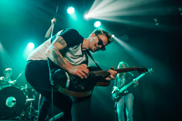 istock Guitarist performing with passion on stage under turquoise lights 2191490190