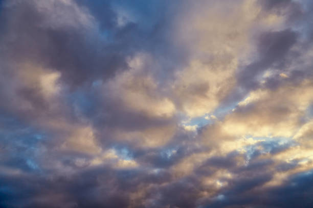 istock Gray clouds bathed in soft sunlight against a blue sky in winter. 2191490436
