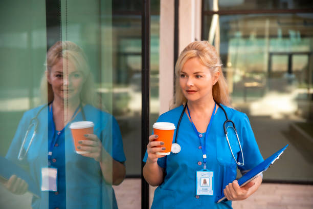 Nurse walking with coffee outside Hospital