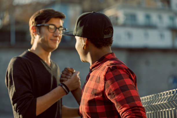 Two young men shaking hands in friendship and respect