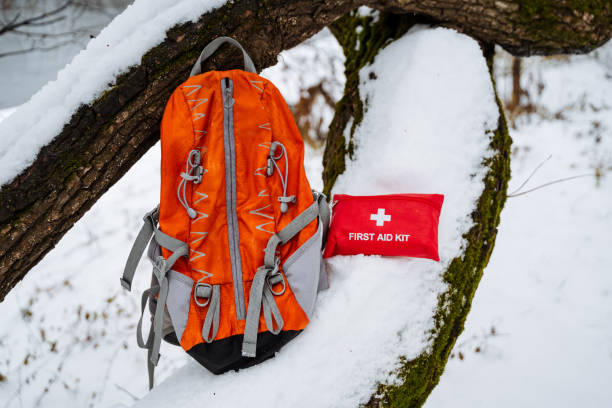 istock An orange backpack, brightly colored and easily identifiable, is resting in the cold, white snow next to a clearly visible first aid kit that stands out against the winter landscape 2191492859