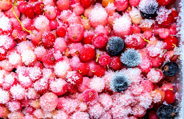 Frozen red and black currants with ice particles on the surface.