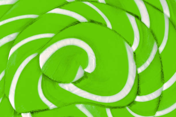Light green colored caramel lollipop texture close-up. Sweet sugary candy.