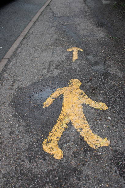 istock Pedestrian footpath with yellow pedestrian symbol with yellow arrow 2191503125