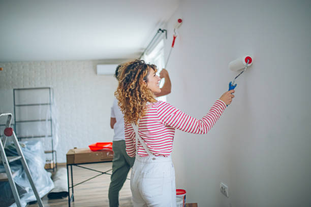 istock Happy Couple Painting a Wall with a Paint Roller 2191504396