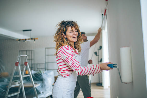 istock Happy Couple Painting a Wall with a Paint Roller 2191504404