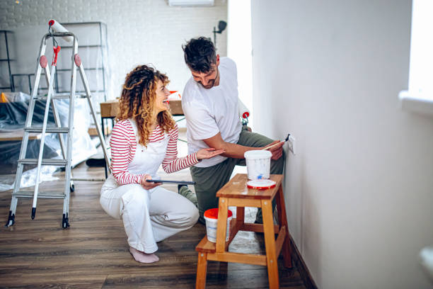 istock Young couple choosing paint color from samples for new home interior design 2191504464