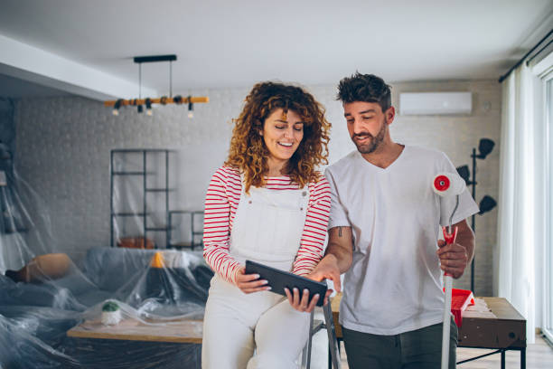 istock Young couple choosing paint color from samples for new home interior design 2191504532