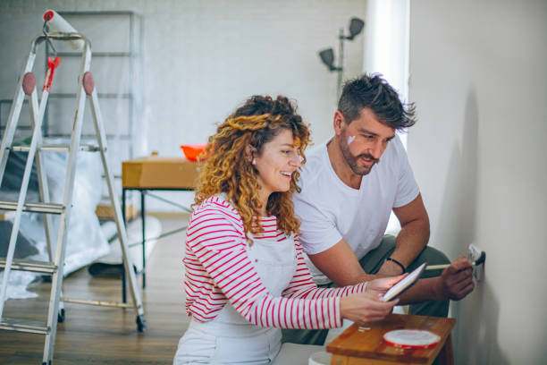 istock Young couple choosing paint color from samples for new home interior design 2191504690