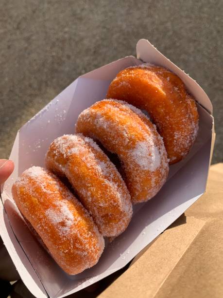 istock Pack of 4 fresh donuts with sugar in cardboard container 2191505896