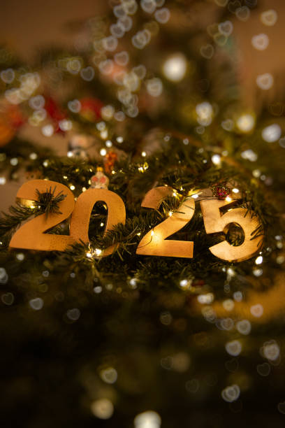 istock Vertical Golden 2025 with bokeh ornament on a decorated Christmas tree, illuminated by warm string lights 2191511140