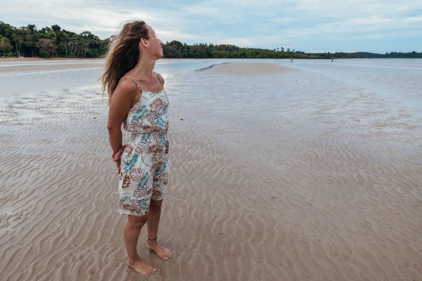 istock Woman Enjoying a Serene Walk on a Sandy Beach 2191511563