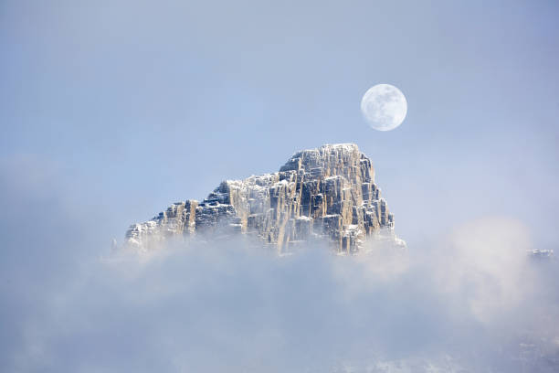 Canada, British Columbia, Roger's Pass mountain in morning mist. full moon rising