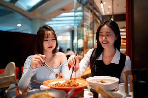 Asian young women eating dinner in Chinese restaurant