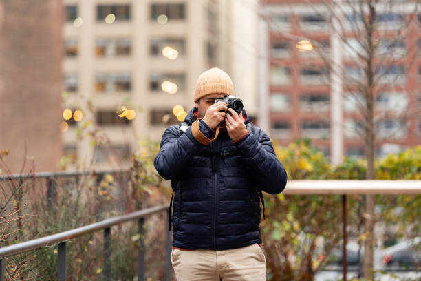 Man walking and taking photos with a camera film in The High Line area in New York City