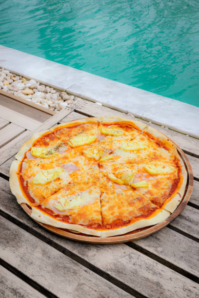 istock Hawaiian pizza, mozzarella, ham, pineapple on wooden tray 2191523065