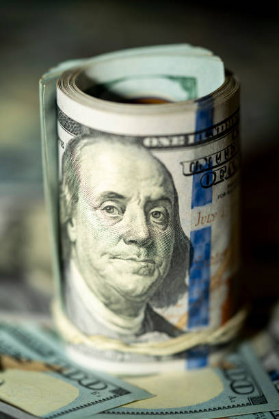 istock Close-up of rolled hundred dollar bills on a table 2191528906