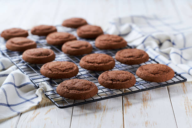 istock Freshly baked chocolate brownie cookies cooling on a black wire rack, with in a light kitchen table, selective focus. 2191539101